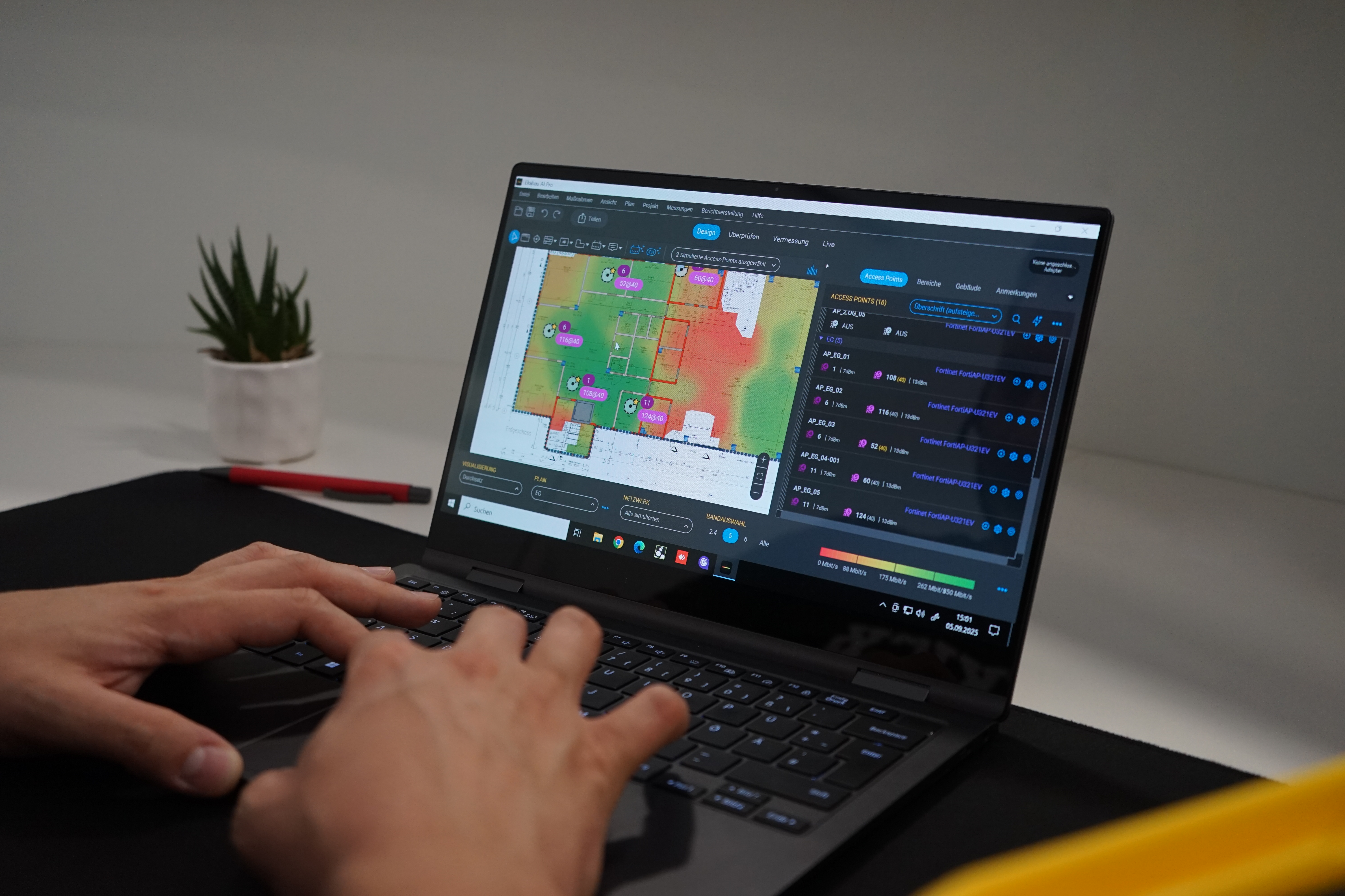 Ein WLAN-Techniker analysiert eine WLAN-Heatmap und die Anordnung der Access Points in Ekahau Ai Pro auf einem Laptop